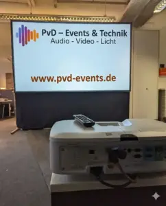 ViewSonic Beamer projeziert das PvD - Events & Technik Logo auf eine professionelle Rahmenleinwand während eines Business-Events.