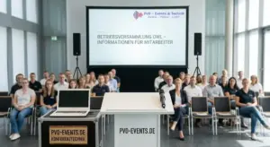 Professionelles Setup für eine Betriebsversammlung mit Rednerpult, Sennheiser Funkmikrofon, großer Leinwand und Beschallungsanlage in einer Firmenlocation in OWL.