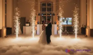 Festlich beleuchteter Hochzeitssaal mit DJ-Pult, Bodennebel beim Eröffnungstanz und Funkelfontänen von PVD Events.