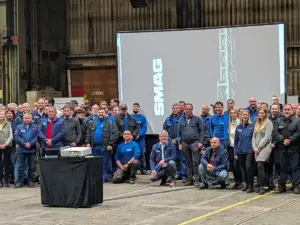 Rebranding-Event bei SMAG in Salzgitter: Große PVD Events Leinwand und Beamer-Projektion in einer gut ausgeleuchteten Industriehalle.