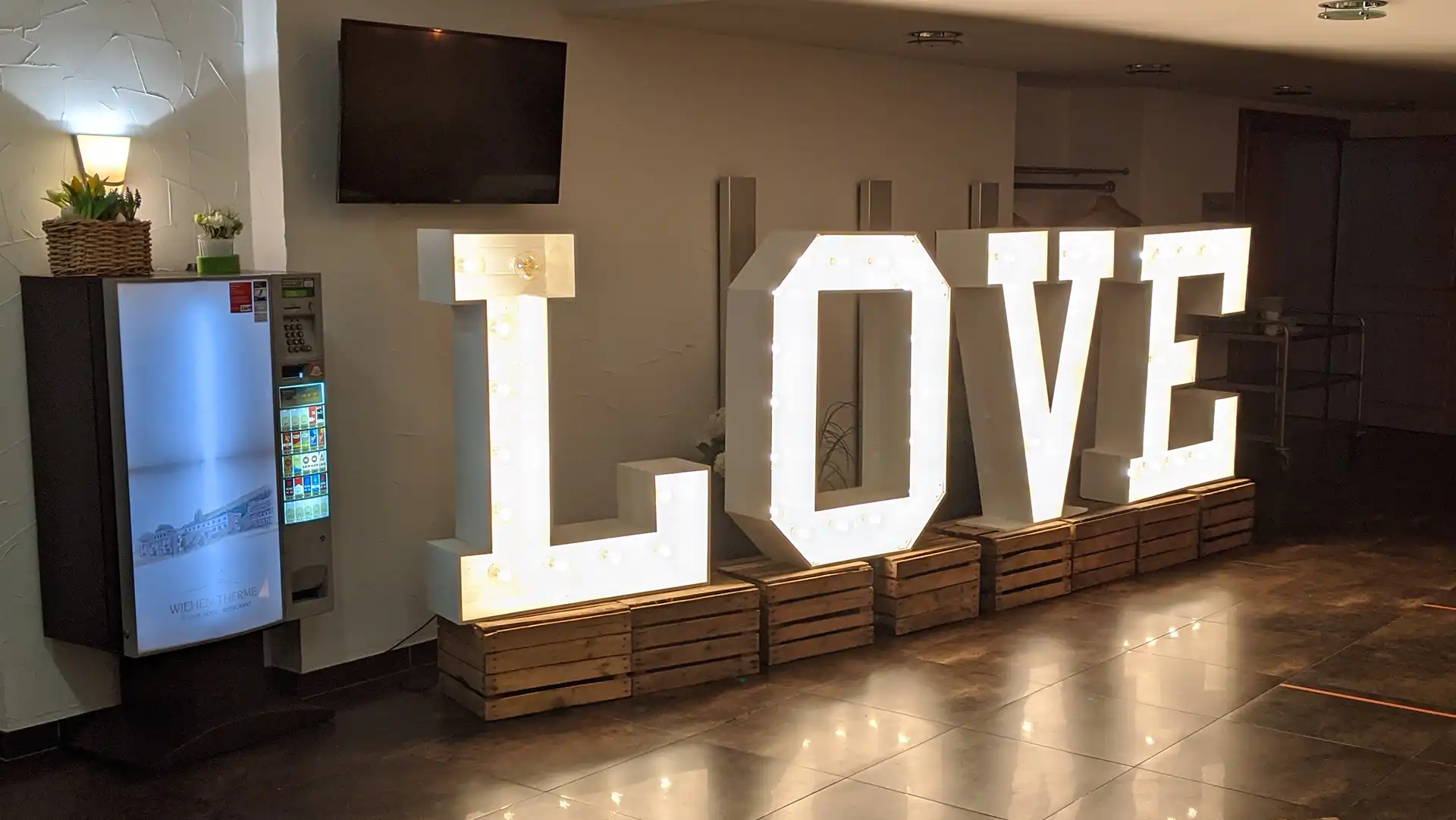 XXL LOVE-Leuchtbuchstaben auf rustikalen Holzkisten als Dekoration für eine Hochzeit in der Wiehen-Therme Hüllhorst.