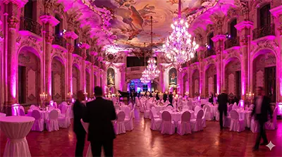 Festliche Gala-Beleuchtung von PvD - Events & Technik im prunkvollen Barocksaal von Schloss Bückeburg. Magenta Illumination der Architektur und festlich gedeckte Tische in 16:9 Breitbild-Ansicht.