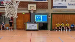 Eine mobile Rückpro-Leinwand zeigt die Spielstandanzeige eines Handballspiels in der Sporthalle Hüllhorst, improvisiert durch PvD - Events & Technik mittels Beamer-Projektion.