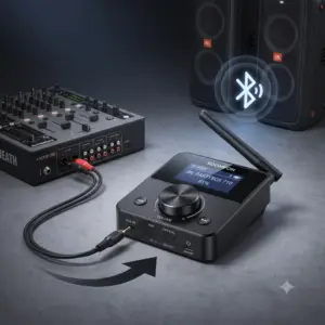 Kompakter schwarzer SOOMFON Bluetooth 5.0 Transmitter mit LCD-Display und Regler, per Klinkenkabel an ein Mischpult angeschlossen, zur drahtlosen Audioübertragung an JBL PartyBox Lautsprecher vor Studiolook-Hintergrund.